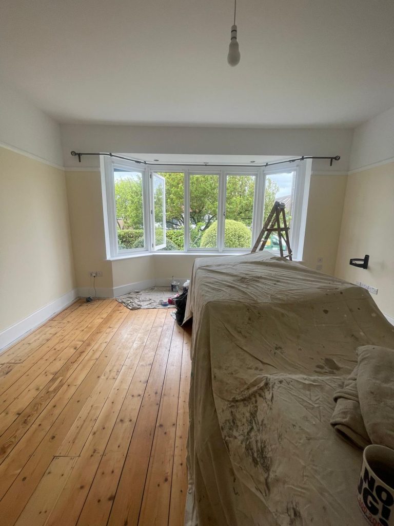 Bedroom painting preparation in Kellaway Avenue BS6 Bristol with furniture covered and bay window area ready for decorating