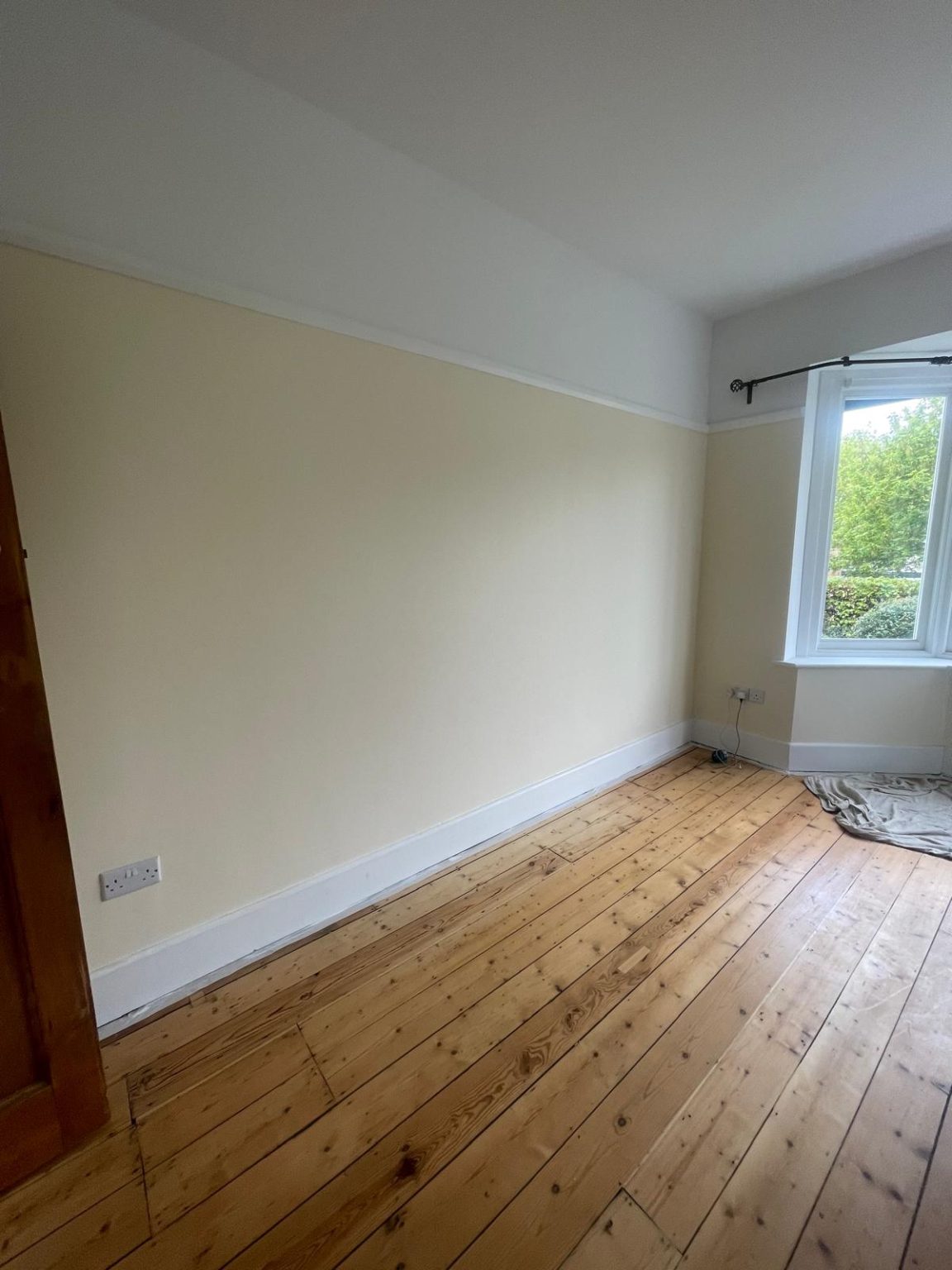 Home 57 Bedroom wall painting in BS6 Bristol with clean finish around bay window and wooden floor